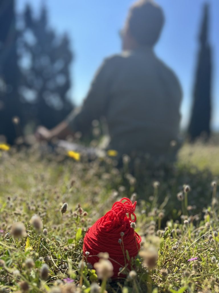 Person Meditating in the background at Ariadnes Garden